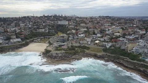 Flying over a beach with a city in the background 1 Stock Footage 106592006