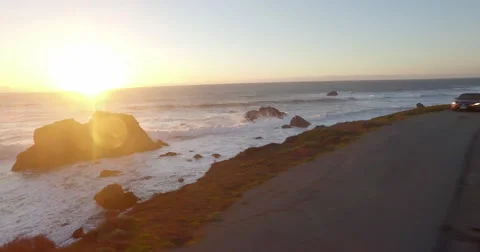 Flying over Beach Cliff Toward Sun at Sunset Video stock 63302875