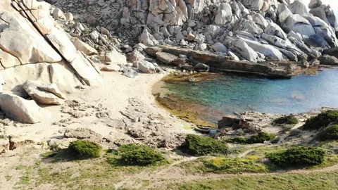 FLYING OVER A BEACH SURROUNDED BY HUGE ROCKS Stock Footage 128842075