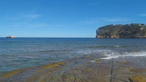 Flying over beautiful blue sea water towards mountain and blue sky Video stock 88001253