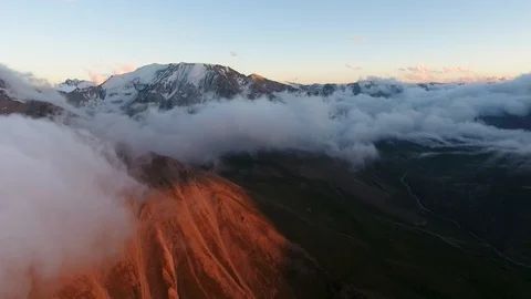 Flying over the beautiful clouds and mountains with evening light. Stock Footage 93389187