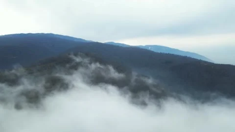 Flying over beautiful clouds with a view of the mountains in the distance Stock Footage 265090954