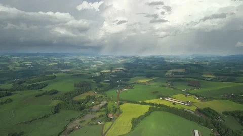 Flying over beautiful green fields with great clouds ahead. Stock Footage 234453746