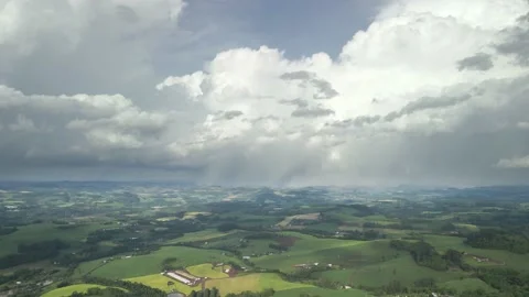 Flying over beautiful green fields with great clouds ahead. Stock Footage 234457791