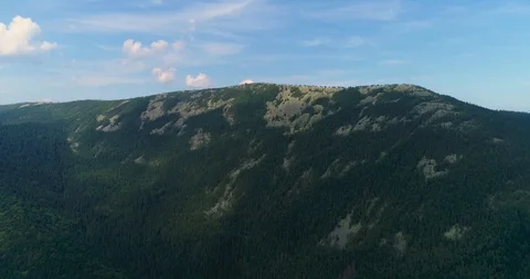 Flying over a beautiful green forest in a mountain landscape Stock Footage 128698464
