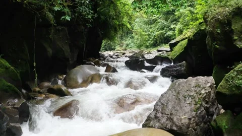 Flying over a beautiful river with large boulders sticking out the fast current Stock Footage 151278673