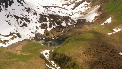 Flying over beautiful spring mountain landscape. Lake in shape heart Video stock 111949585
