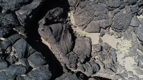 Flying over black bed of lava towards dark volcano. Desertic volcanic landscape 스톡 동영상 103479111