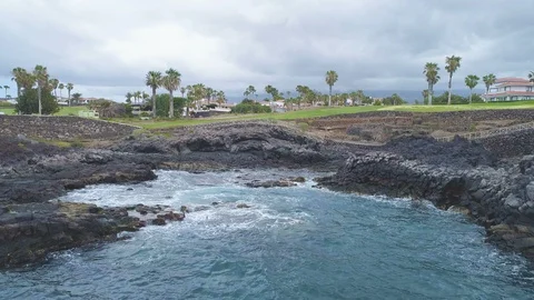 Flying up over blue ocean, golf course green fields in cloudy day Video stock 90810549