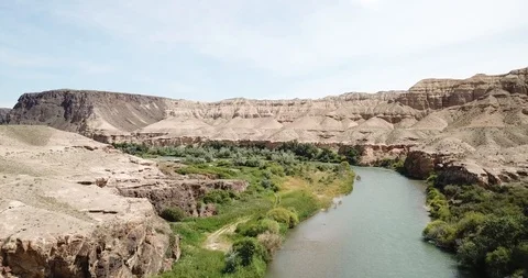 Flying over the blue river. Wide river. On the shore of green grass, hills. Vídeos de archivo 100766593