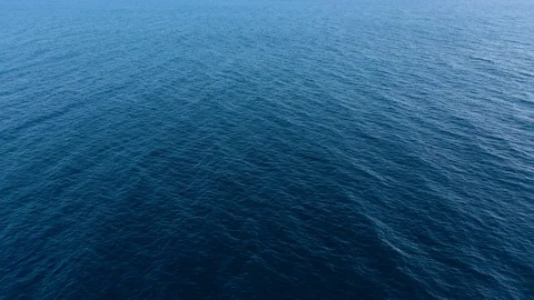 Flying over the blue surface of the sea or ocean Stock Footage
