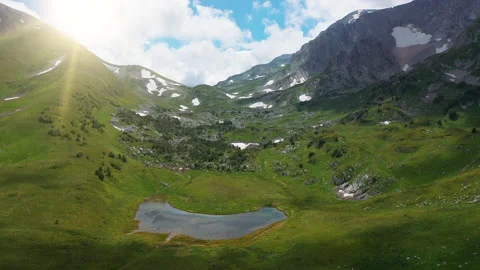 Flying over breathtaking beautiful mountain covered with dense grass, trees and Stock Footage 133683236