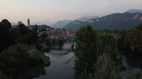 Flying Over Bridge And River Towards a Italian village Stock Footage 160955803