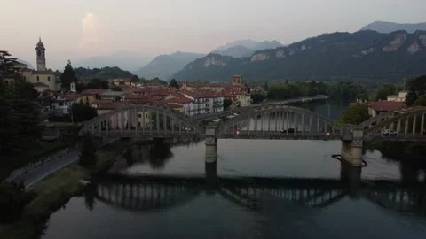 Flying Over Bridge And River Towards a Italian village Stock Footage 161065012