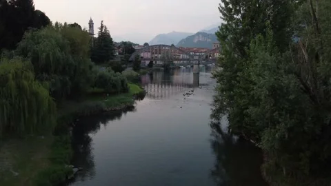 Flying Over Bridge And River Towards a Italian village Stock Footage 161065189