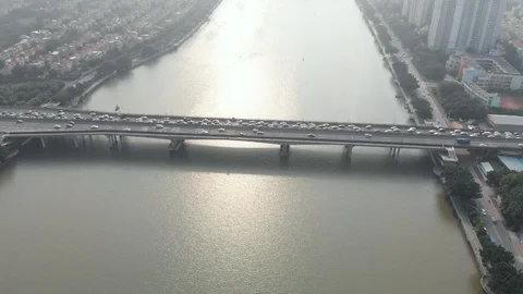 Flying over the bridge over the river on which there is a huge stream of cars. Stock Footage 113808658