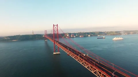 Flying over the Bridge Ponte 25 de Abril on the Tagus river in Lisbon at morning Stock Footage 63802539