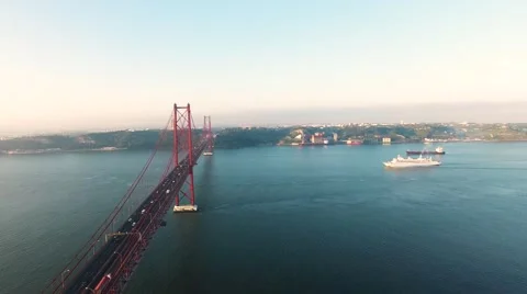 Flying over the Bridge Ponte 25 de Abril on the Tagus river in Lisbon at morning Stock Footage 63803766