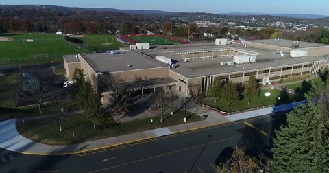Flying over Bristol CT High Central school and showing football field Stock Footage 82326902