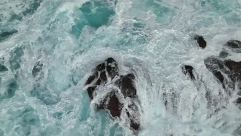 Flying over bubbling blue ocean water with white foam. Ocean waves crash on Stock Footage 214660281