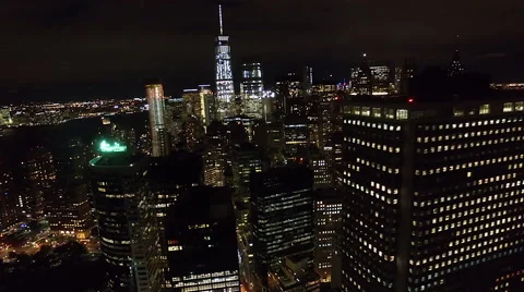 Flying over the buildings and skyscrapers of New York City at night aerial Stock Footage