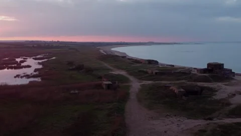 Flying over the bunkers on the coast and with the sunset in the background. Stock Footage 263375640