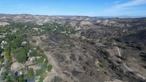 Flying over a burn area on the edge of a neighborhood in Southern California Stock Footage 100338773
