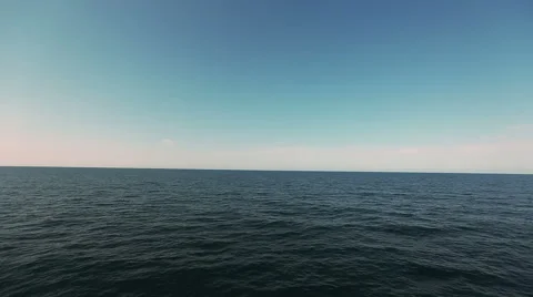 Flying over calm ocean blue sky and water Stock Footage