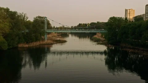Flying  over a calm river and under a blue bridge Stock Footage 112085927