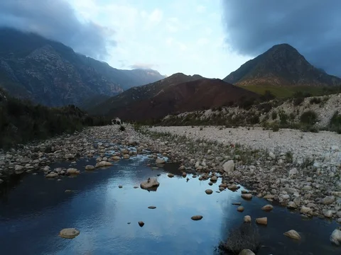 Flying over Calm River with Beautiful Mountains Behind Stock Footage 79145839