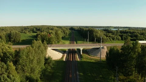 Flying over car road junction with bridge and railway under it at sunny day. Video stock 126903848