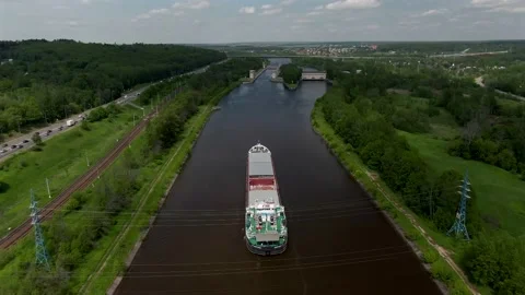 Flying over a cargo commercial ship sailing down the river Video stock 132086895