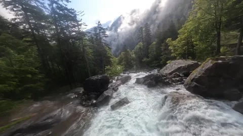 Flying over a cascading rapid waterfall in the mountains. Green sunny summer Stock-Footage 243980343