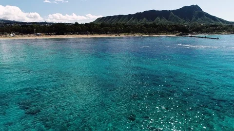 Flying over clear blue water towards Diamond Head, Honolulu, Hawaii. Video stock 109367471