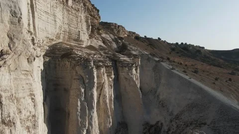 Flying over a cliff of a white cliff overlooking the adjoining valley Video stock 132193391