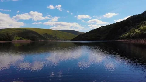 Flying over cloud reflections on Meldon resevoir, Devon, UK 動画素材 135519732