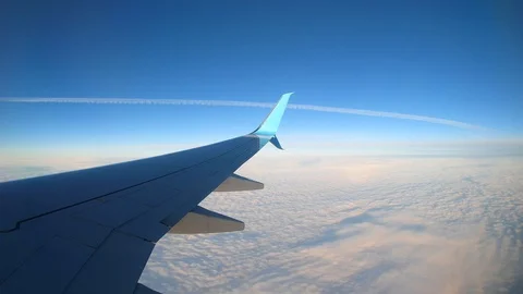 Flying over clouds amid the blue sky on the plane Stock Footage 129736784
