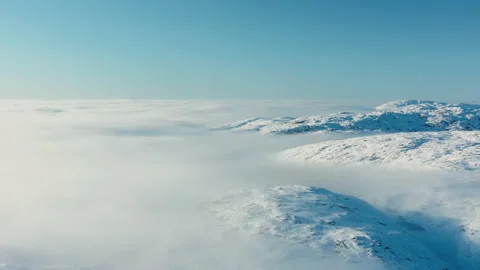 Flying over clouds and snow-capped peaks. View of the snow-capped mountain peaks Video stock 145757493