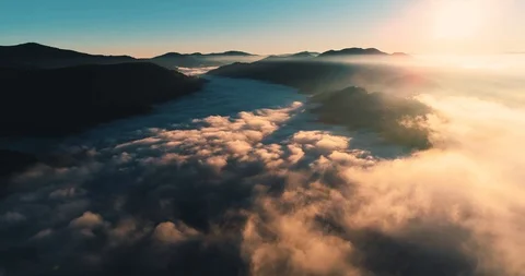Flying over the clouds during morning sunrise Stock Footage 128695403