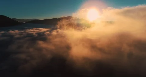 Flying over the clouds during morning sunrise Stock Footage 128695457