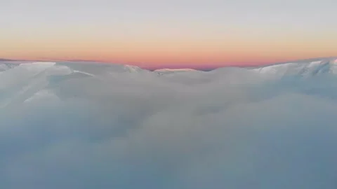 Flying over the clouds in the mountains. Aerial view. Colorful winter sunset in Video stock 147224637