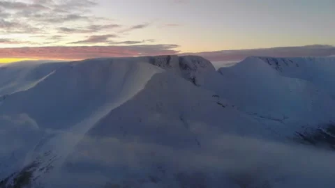 Flying over the clouds to a snowy mountain at sunset. Aerial view. Video stock 147224906