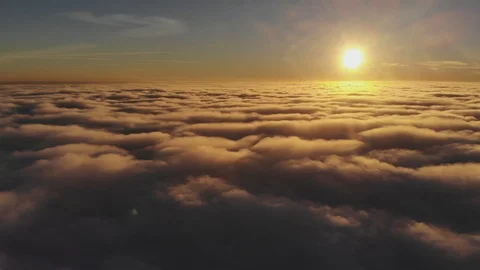 Flying over clouds towards sun on background of golden sunset Stock Footage 104048138
