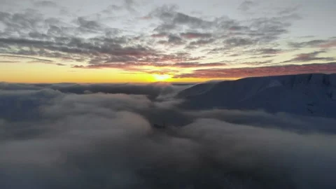 Flying over the clouds towards the sunset. Twilight in the winter mountains Video stock 154610717