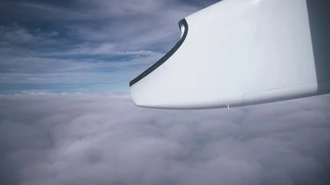 Flying over the clouds. View from plane aircraft passenger window. Clouds and sk Stock Footage 84146120