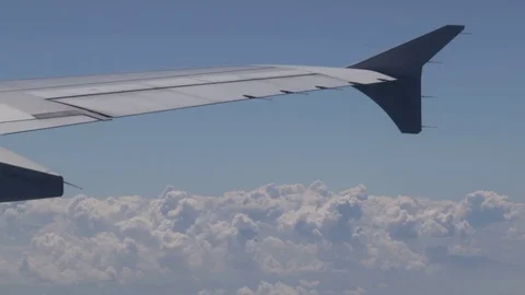 Flying over the clouds, view from the plane on a blue sky and cumulus clouds. Stock Footage 120539991