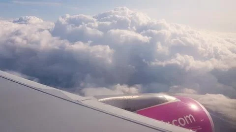 Flying over the clouds. View from plane aircraft passenger window with clouds Foto stock