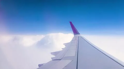 Flying over the clouds. View from plane aircraft passenger window with clouds Stock Photos