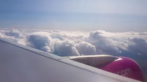Flying over the clouds. View from plane aircraft passenger window with clouds Foto stock