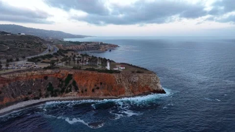 Flying Over the Coastline at Sunset with a Lighthouse Video stock 340579368